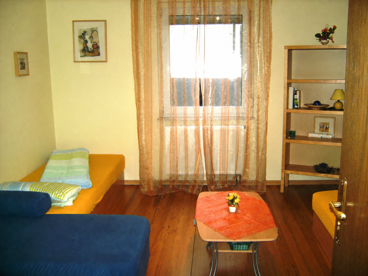Wohn- und Schlafbereich mit Sofa, Bett und Fenster